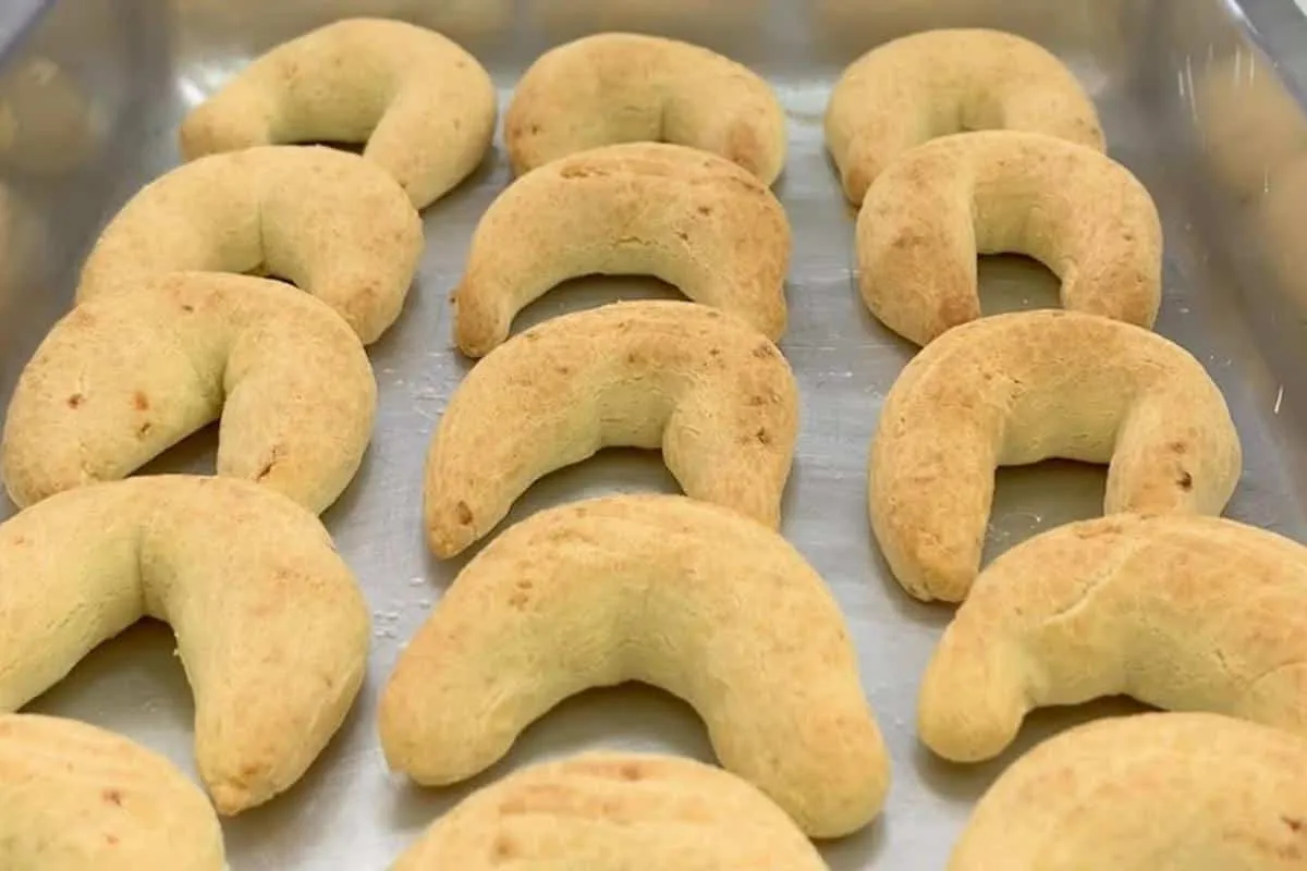 Biscoito de queijo assado para comer acompanhado de uma xícara de café
