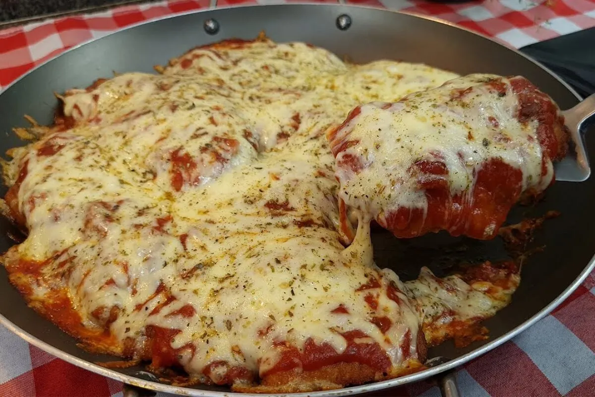 Frango à parmegiana suculento e com bastante queijo que não fica engordurado