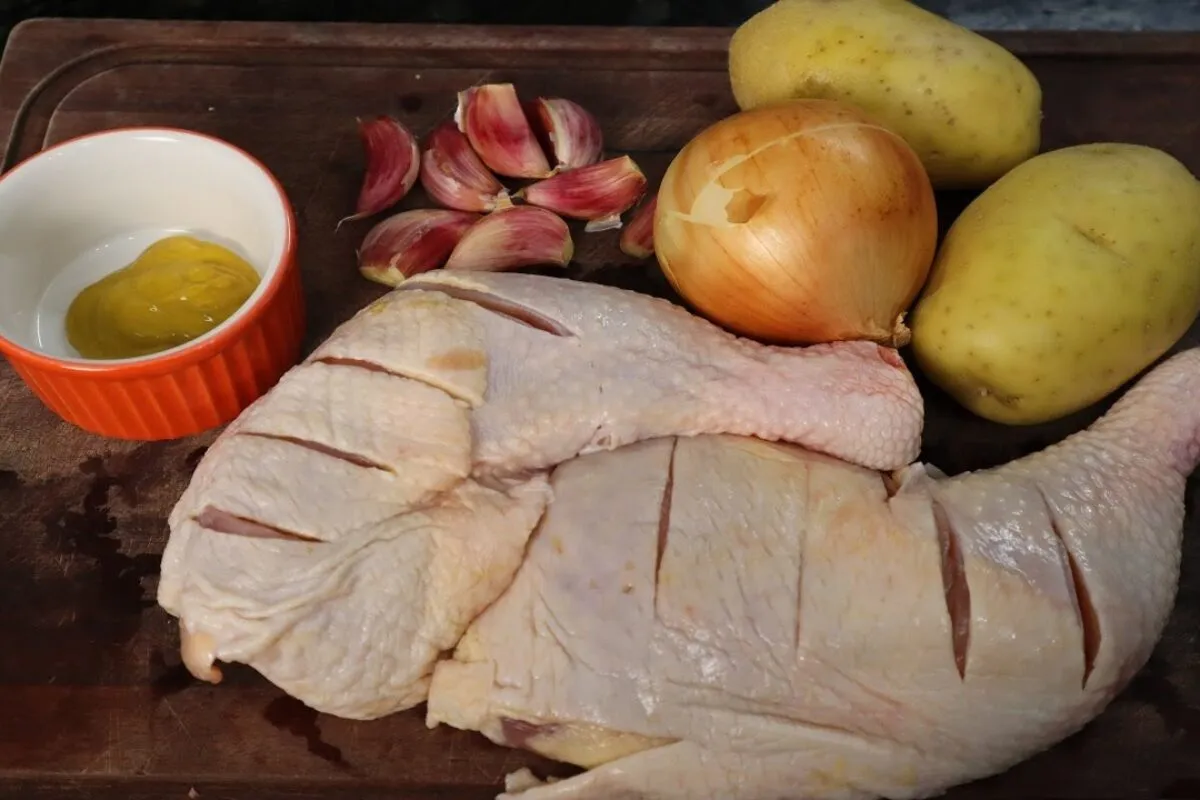 Frango assado com batata bem temperado, coxa e sobrecoxa douradas e suculentas