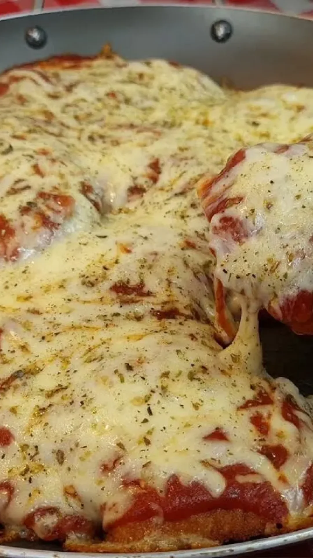 Frango à parmegiana suculento e com bastante queijo que não fica engordurado